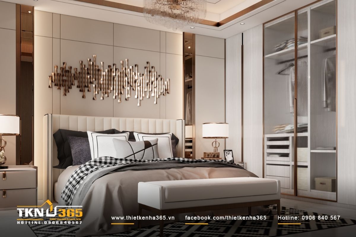 Mảng tường sau giường xử lý phẳng, kết hợp điểm nhấn kim loại ánh đồng giúp không gian sang trọng nhưng không phô trương