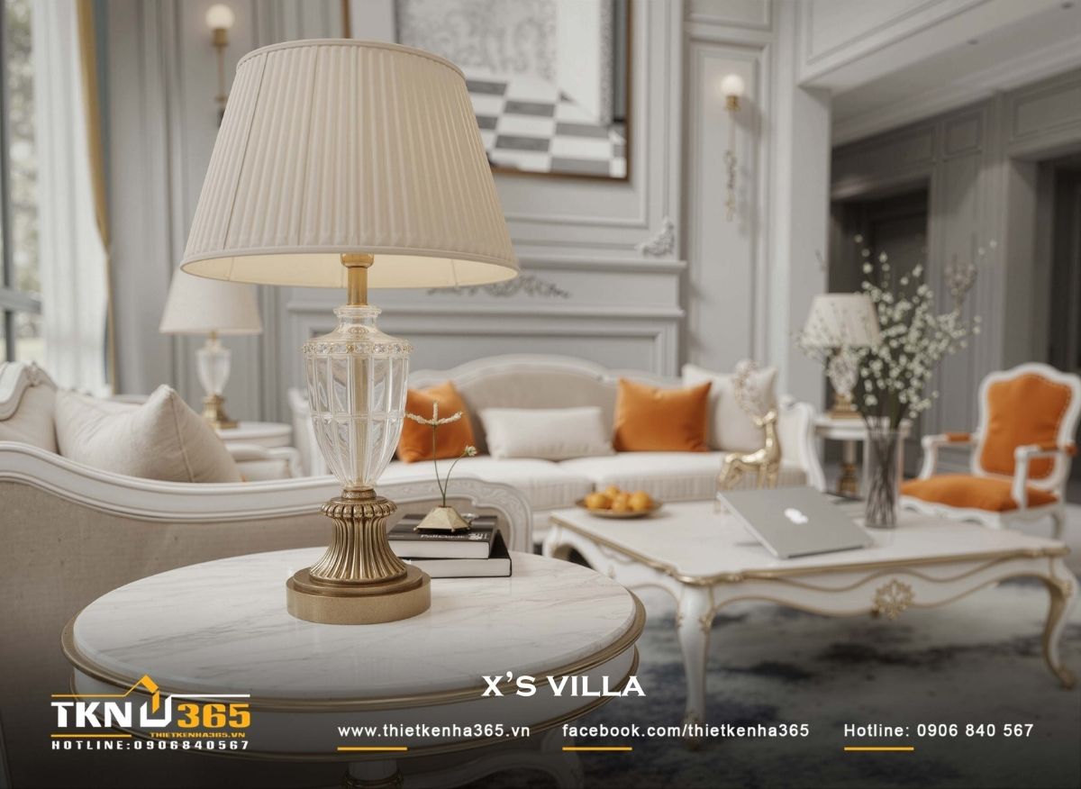 Bộ sofa sáng màu sắp đặt quanh bàn trà trung tâm, đặt trên thảm lớn để định hình khu vực sinh hoạt ấm áp giữa không gian cao thoáng